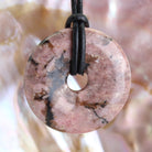 Rhodonit Donut Anhänger Kettenanhänger 30 mm mit Lederband Halskettenanhänger Kettenschmuck Stein Trommelstein Anhänger Schmuck Schmuckstein Rohstein Rohstück Edelstein Heilstein Silberanhänger Silberschmuck Schutzstein Glücksstein