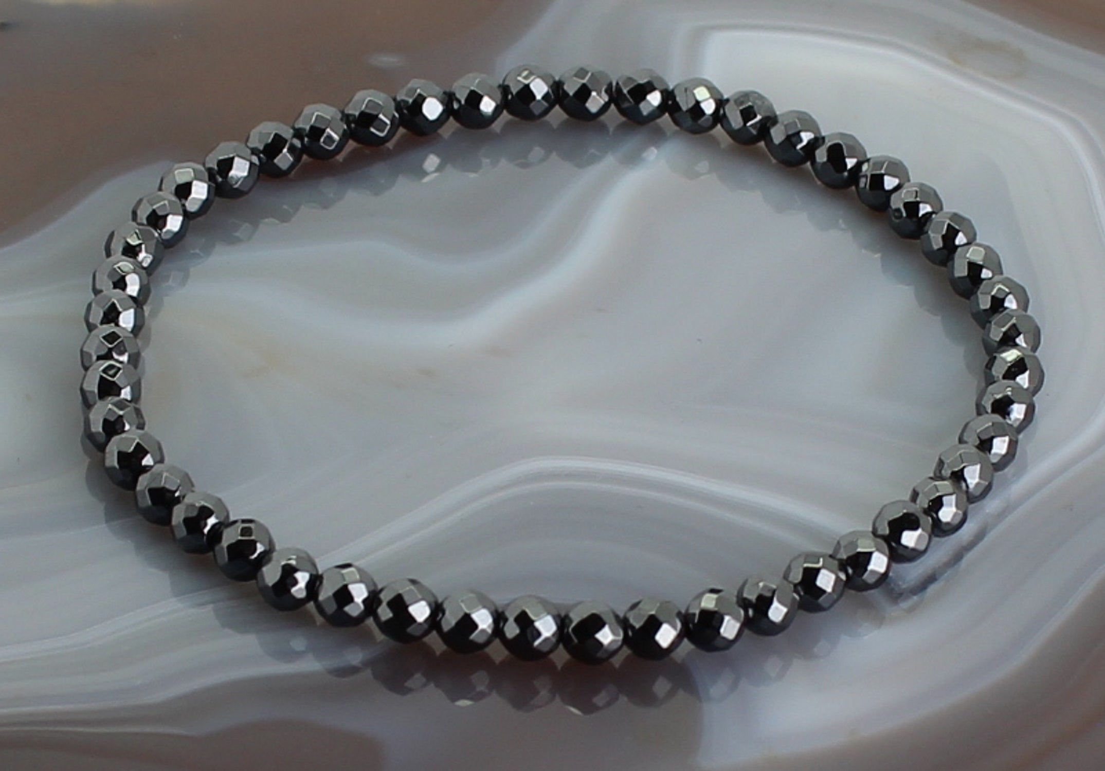 Armband aus Hämatit facettiertes Armband Stein Trommelstein Anhänger Perlen Kugeln Heilstein Edelstein Kugelarmband Perlenarmband Edelsteinarmband Stretcharmband Gummiarmband Armschmuck Schmuckstein Rohstein Rohstück Schmuck Kettenanhänger